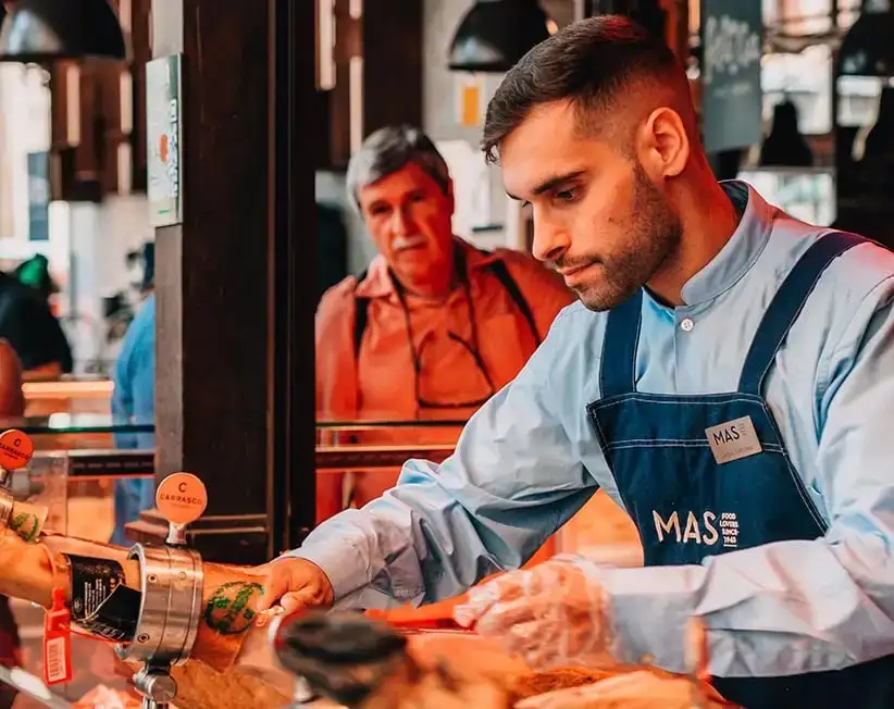 Madrid, İspanya'daki bir pazarda jambon tezgahında çalışan bir adam