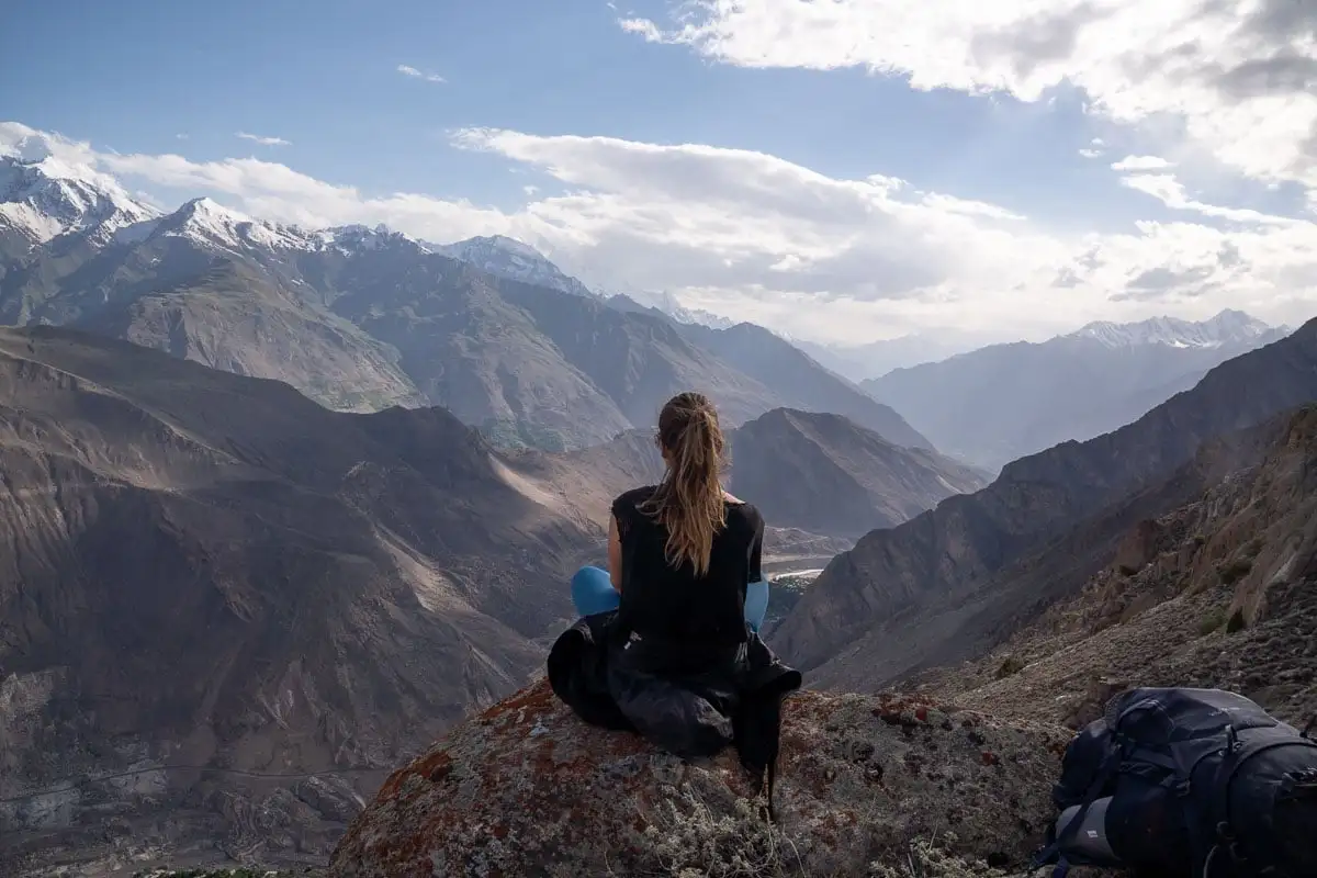 fille assise sur un rocher avec vue sur la montagne au Pakistan