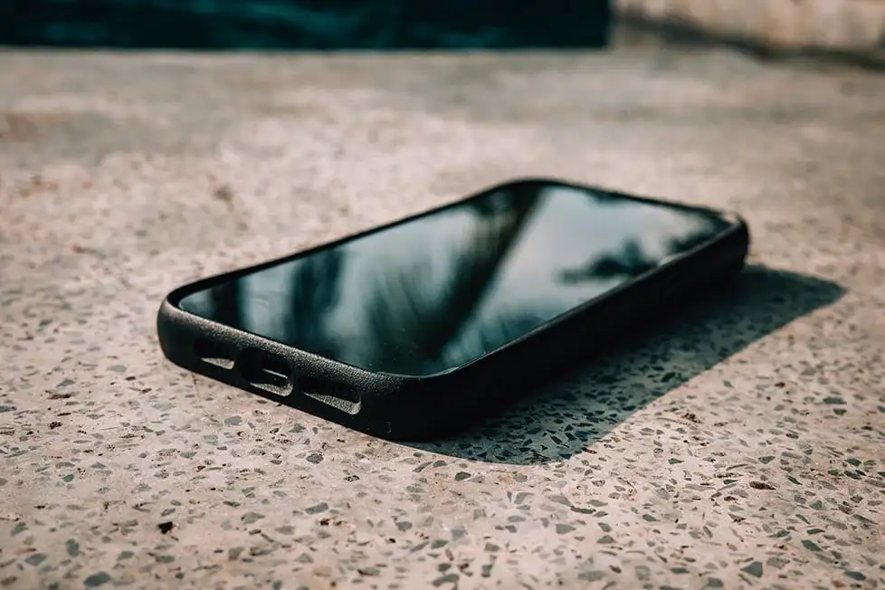 Un gros plan d'un téléphone portable posé sur un dessus de granit gris