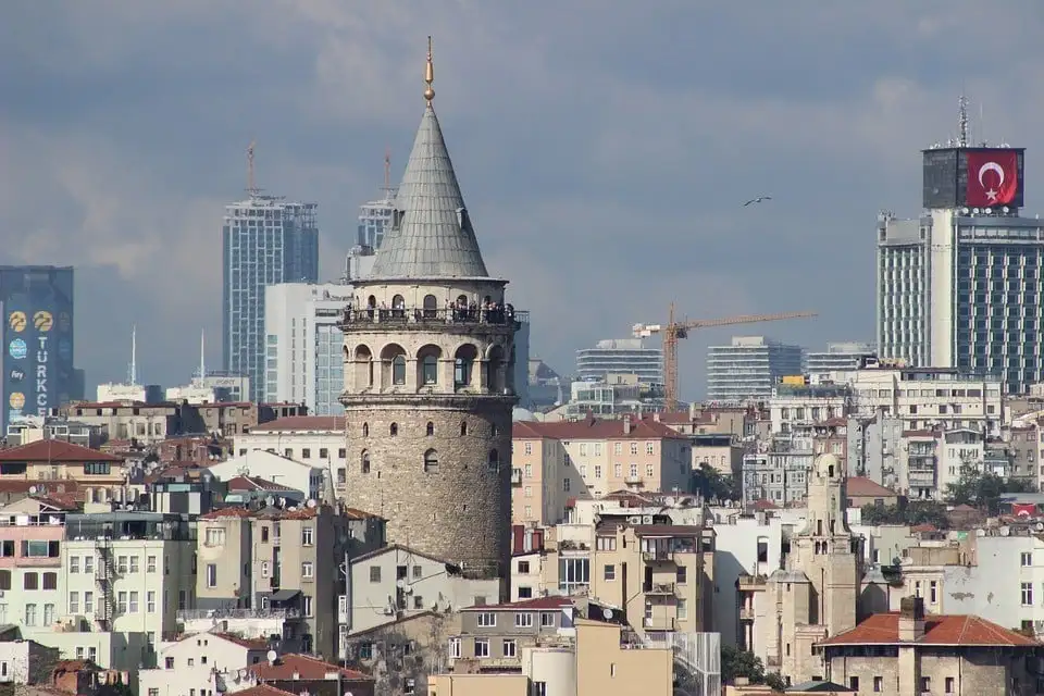 Deux hommes pêchent depuis un pont sur le Bosphore à Istanbul, en Turquie, avec une grande mosquée en arrière-plan.