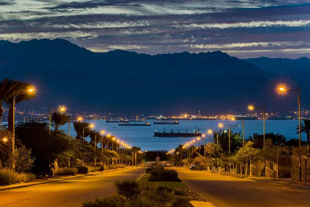 Ville d'Eilat et rue principale à l'aube avec la mer Rouge et les montagnes jordaniennes derrière