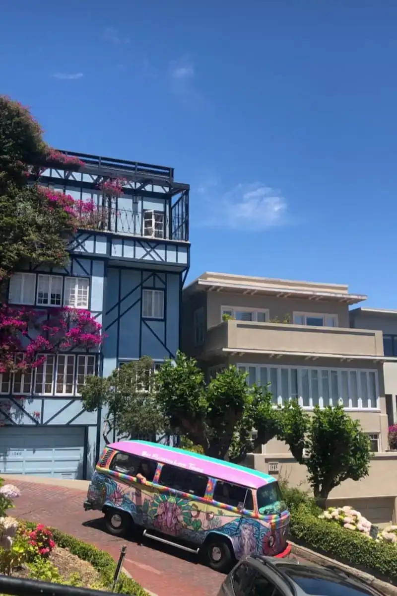 Uma van volkswagen hippie dirigindo pelas ruas coloridas de São Francisco, Califórnia, EUA