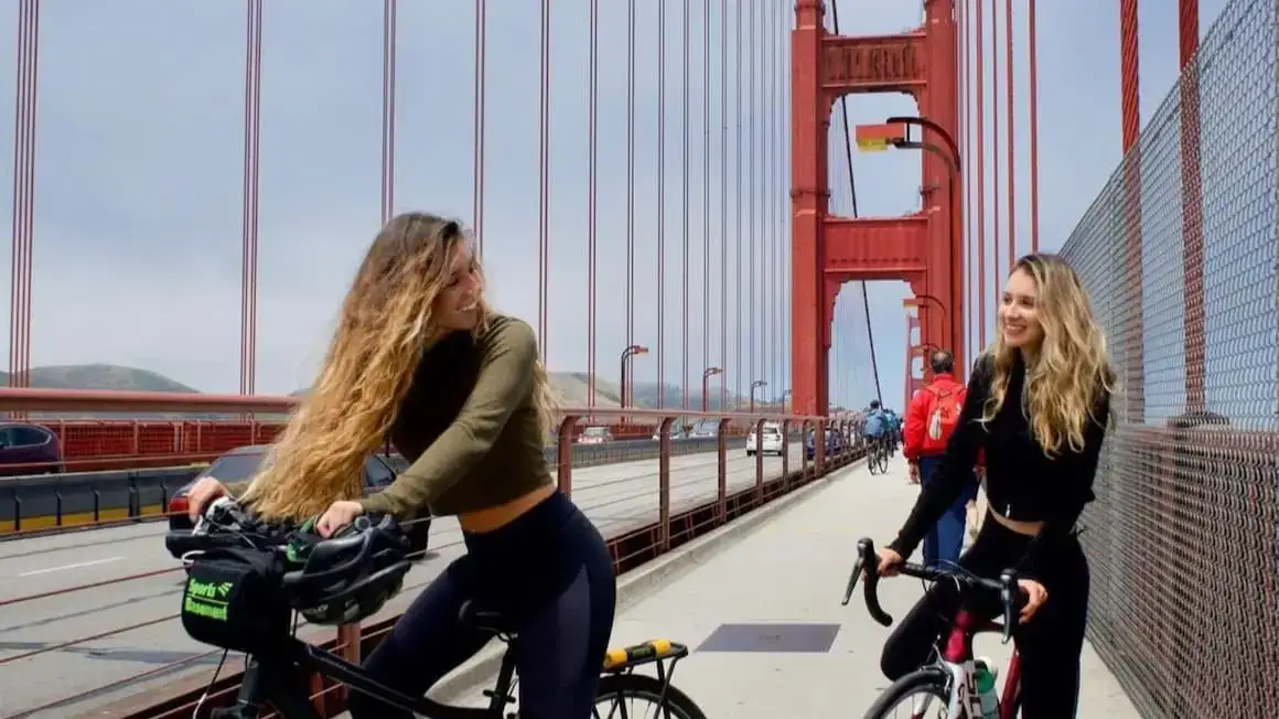 Duas meninas andando de bicicleta pela Ponte Golden Gate, Estados Unidos da América.