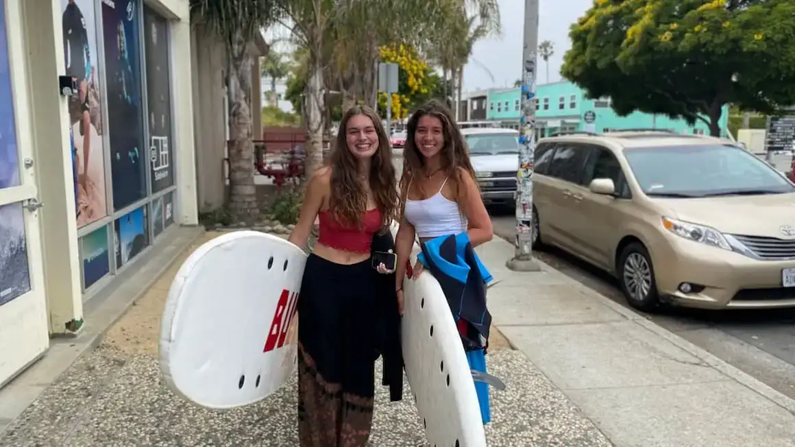 2 meninas segurando pranchas de surf foram para a praia dos Estados Unidos da América.