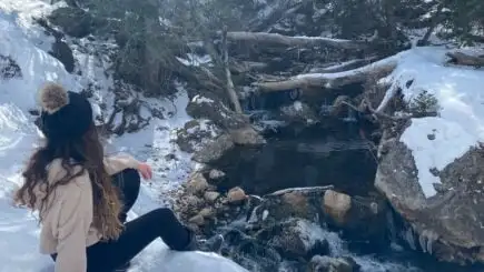Área da piscina ao sol no Black Forest Lodge, Big Bear CA. Guarda-sóis e espreguiçadeiras vermelhos