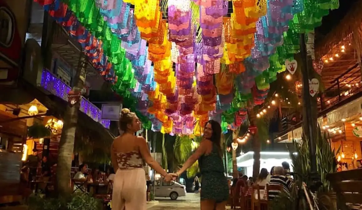 Deux filles se tenant la main sous les drapeaux mexicains vibrants qui bordent les rues de Sayulita.