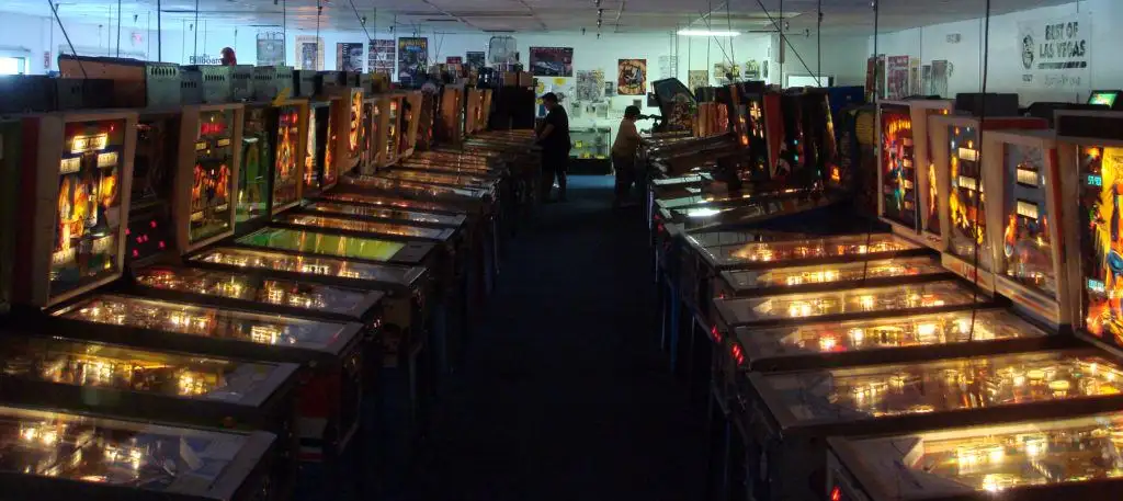 Fileiras de máquinas de pinball com dois jogadores jogando no Pinball Hall of Fame