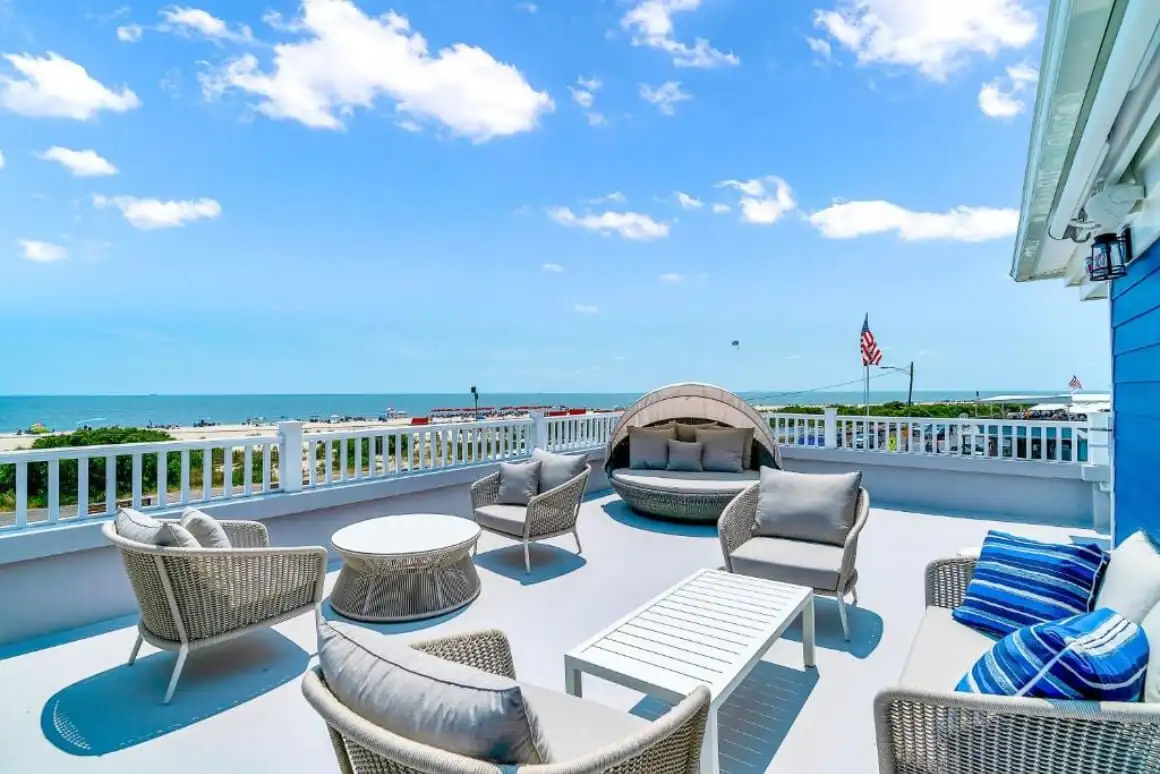 Wildwood Crest Cape May'de mavi gökyüzü ve mavi suları olan uzun beyaz kumlu plaj