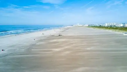 Cape May Sahili'ndeki kumlu kıyının önündeki kayalardan su kırılıyor