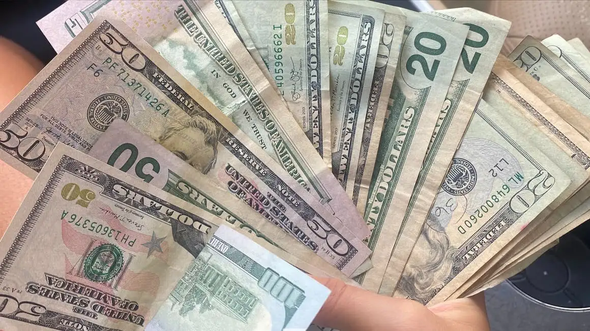 seseorang yang memegang dolar Amerika Syarikat