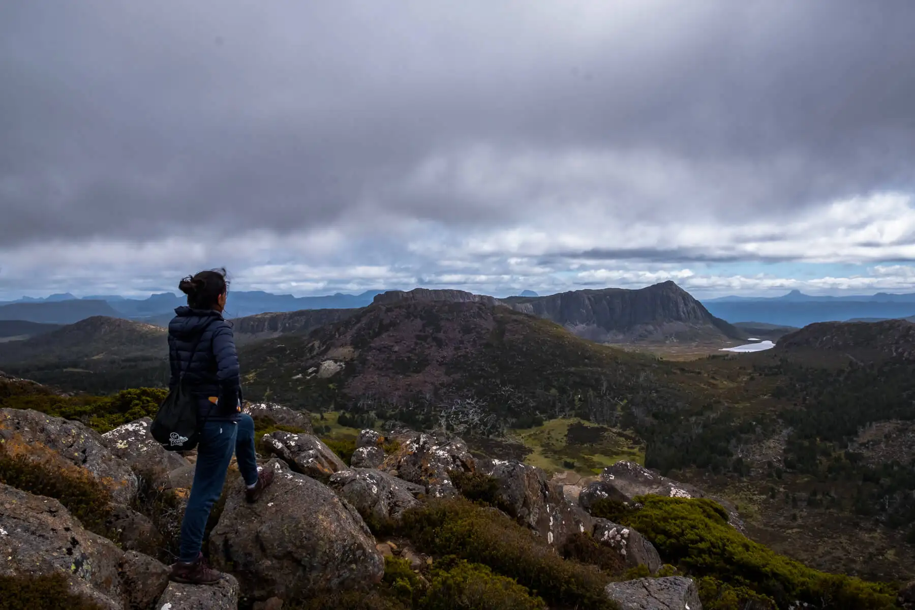 Un routard en randonnée en Tasmanie regarde la zone de conservation du plateau central