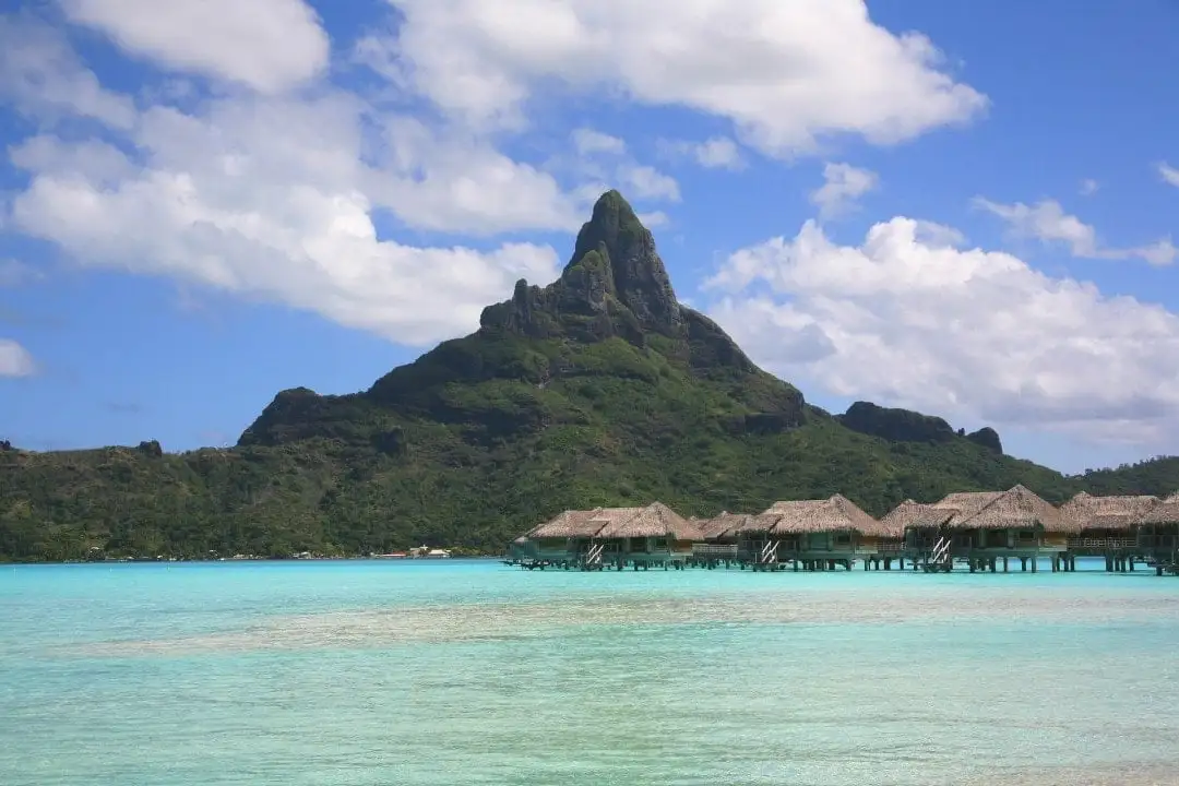 Tahiti-bungalows boven het water en een deel van zijn geschiedenis