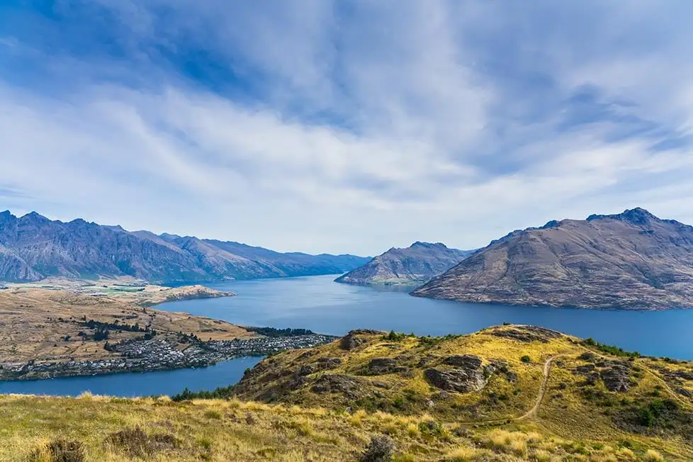 La vue depuis une colline sur la ville et les montagnes au-delà, près de Queenstown, en Nouvelle-Zélande