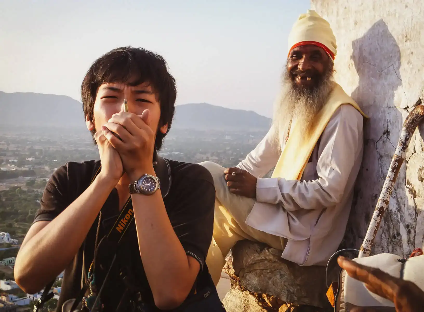 Un routard voyageant en Inde fume de l'herbe avec un vieil homme du coin