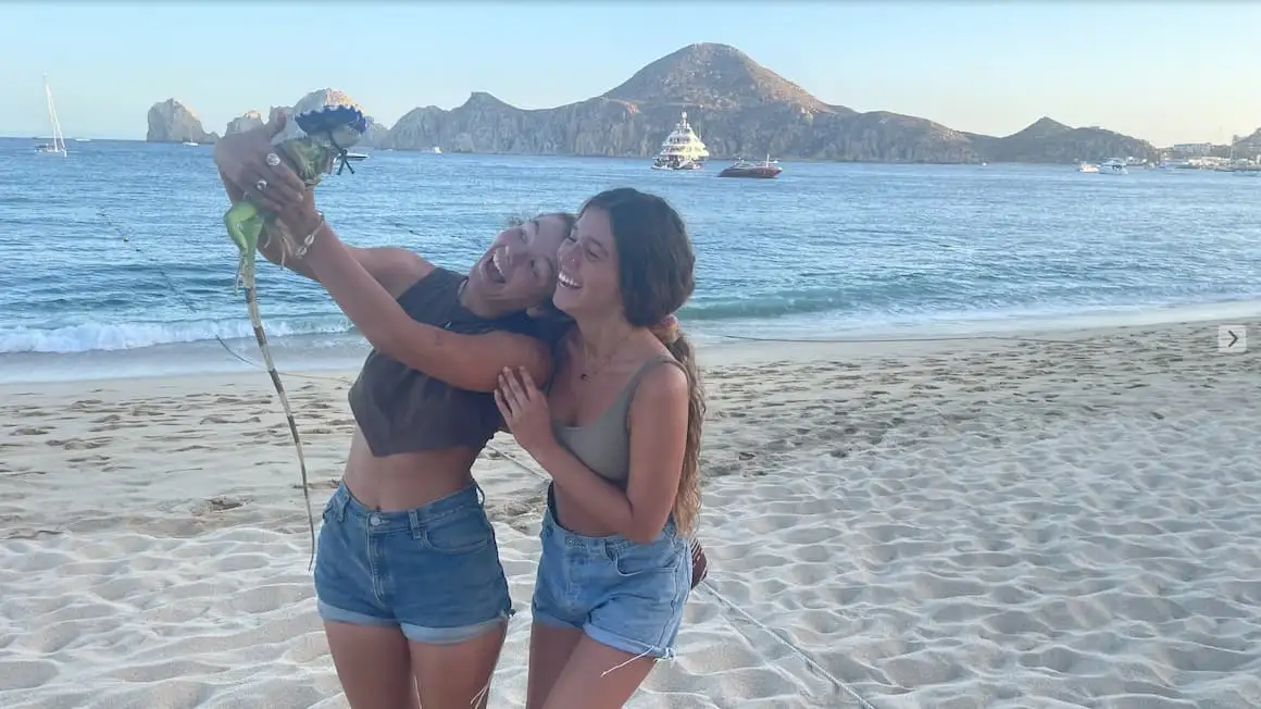 deux amis sur une plage au Mexique tenant un lézard sur lequel se trouve un Sombrero
