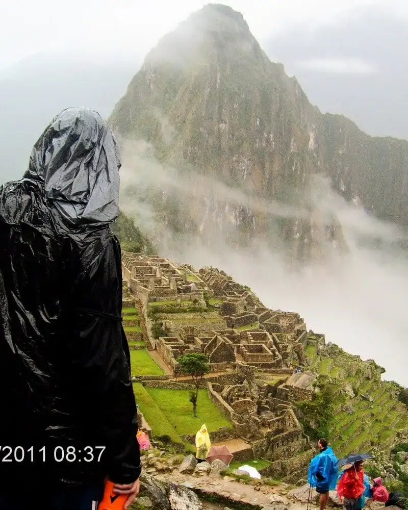 Routard regardant la vieille ville de Machu Picchu un jour de pluie.