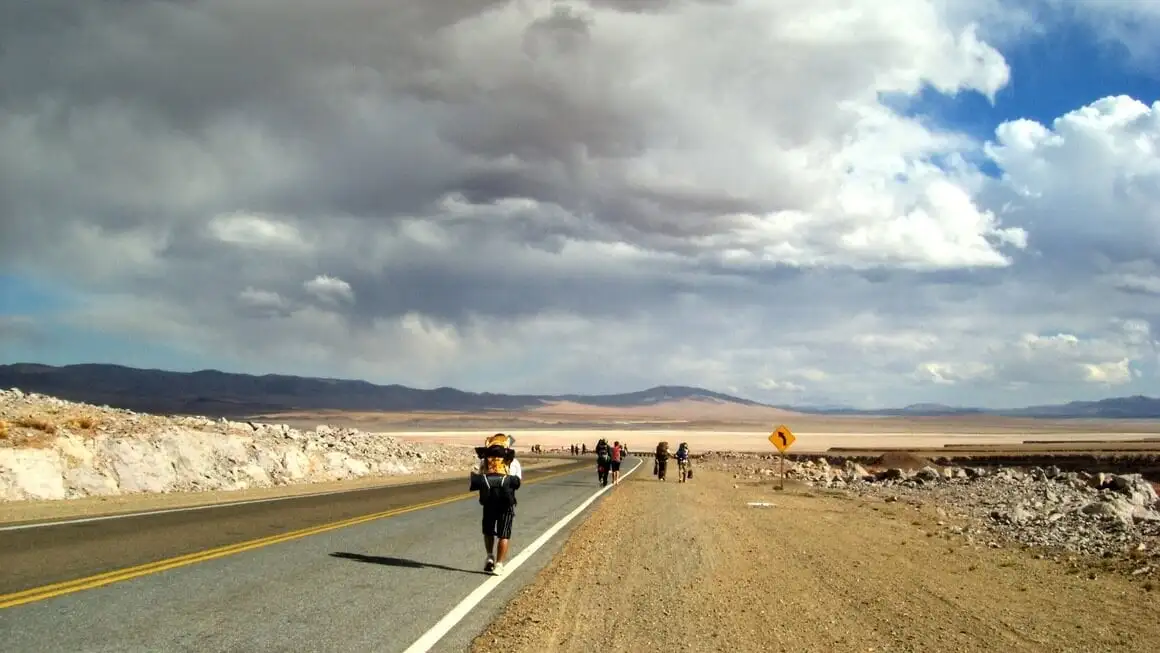 Routards faisant de l'auto-stop sur la route dans le désert d'Atacama, au Chili.