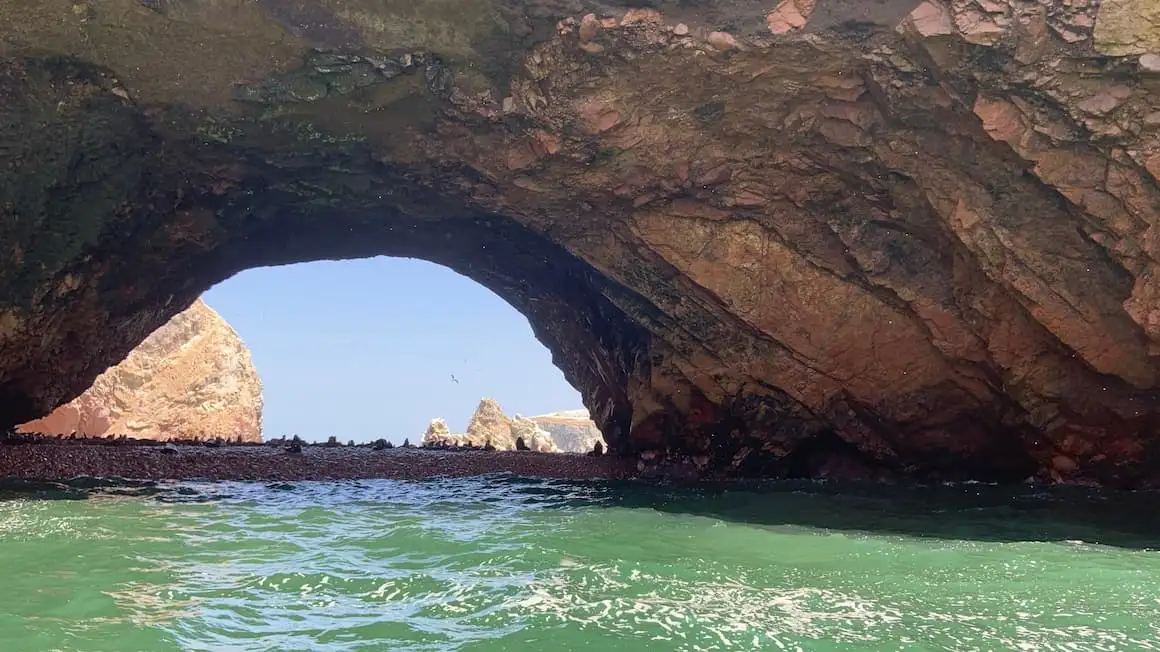 une grande grotte au Pérou avec des phoques au loin