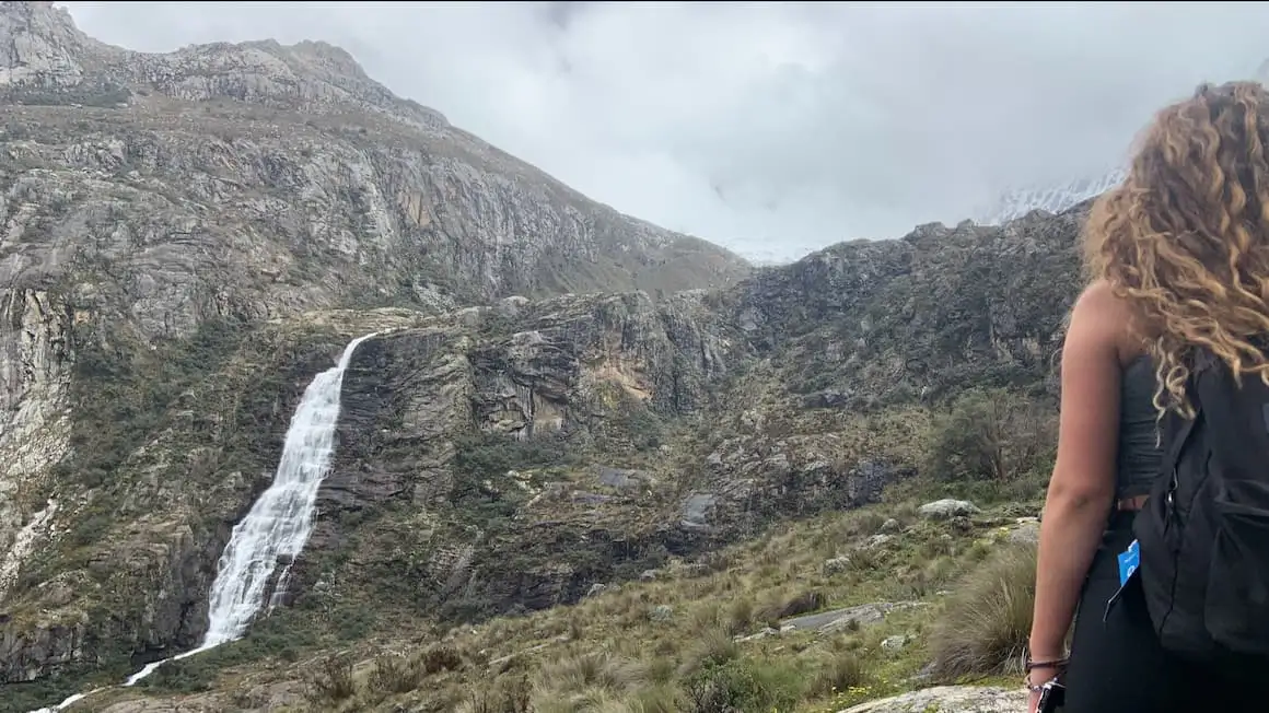 fille debout à côté d'une cascade lors d'une randonnée au Pérou