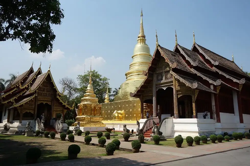Templos de madeira ornamentados e uma estupa dourada em Chiang Mai, Tailândia