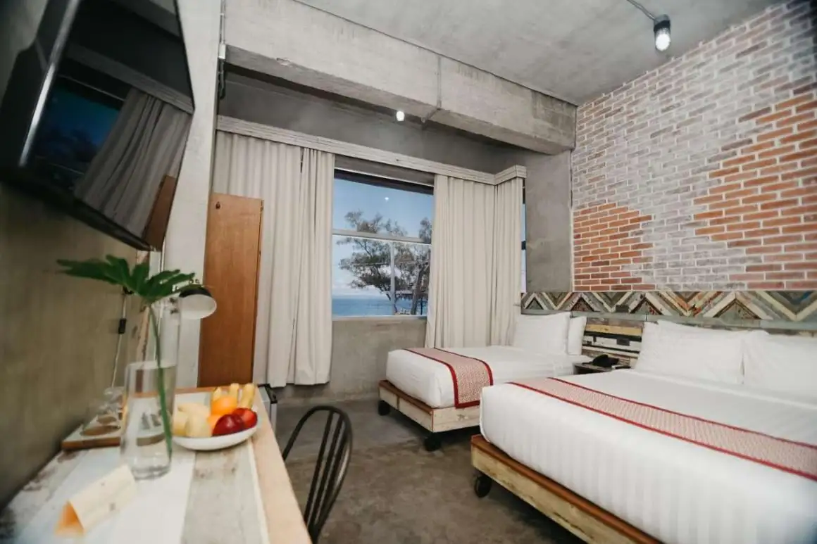 Un lit queen et un lit jumeau, une télévision et un coin salon au Bricks Hotel