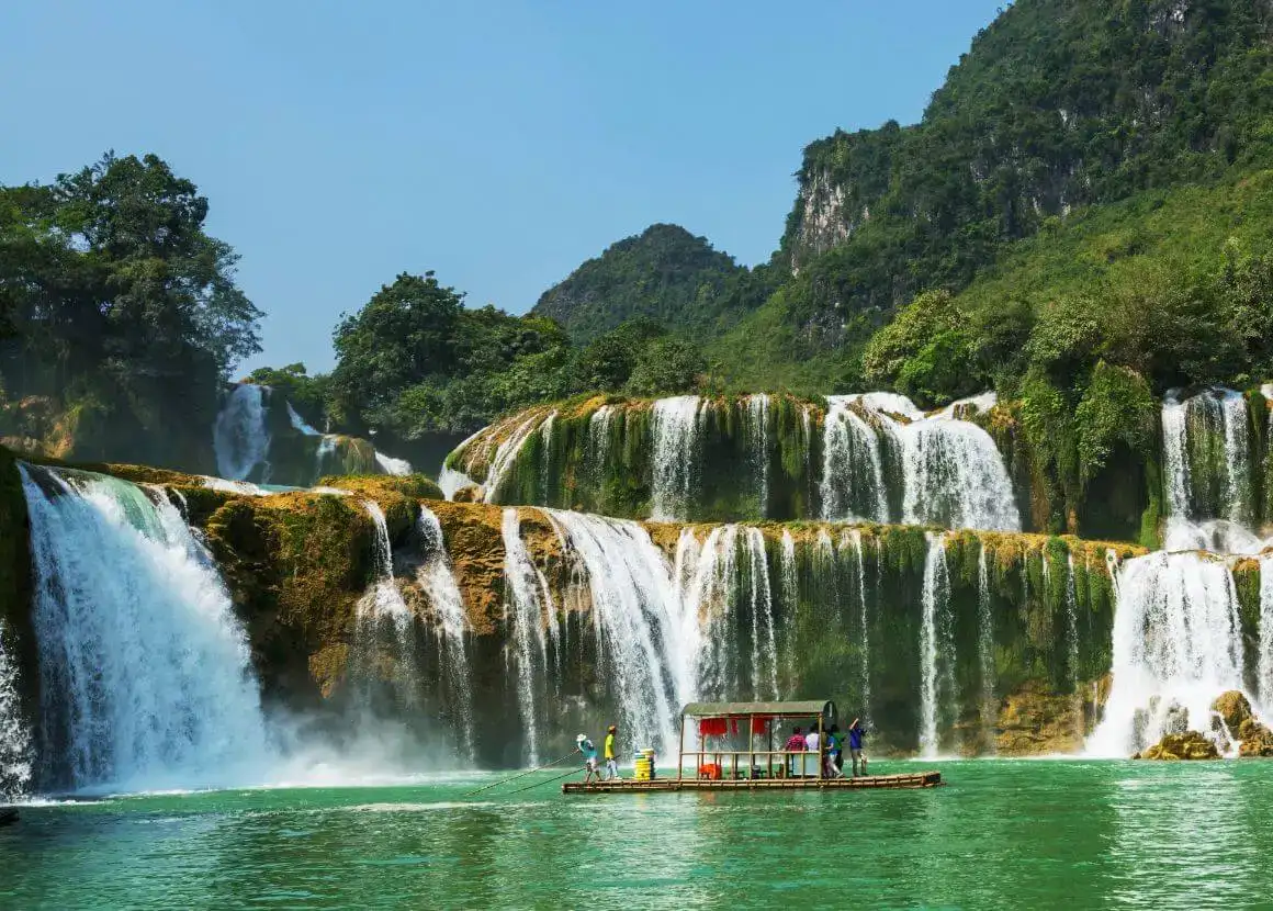 voyageur avec un chapeau traditionnel marchant devant un temple à ninh binh