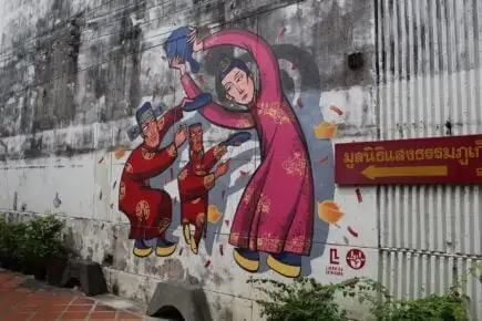 Art de rue représentant une femme et deux hommes se déplaçant dans la ville de Phuket.