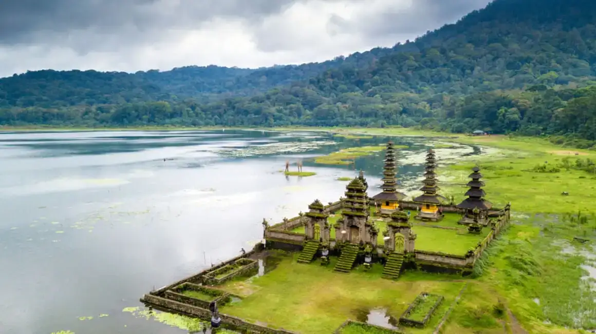 Vue aérienne basse d'un temple hindou au bord d'un lac bleu.