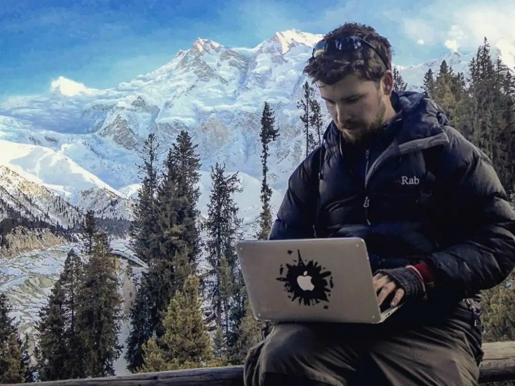 Hatton travaillera sur l'ordinateur portable avec fond de montagne