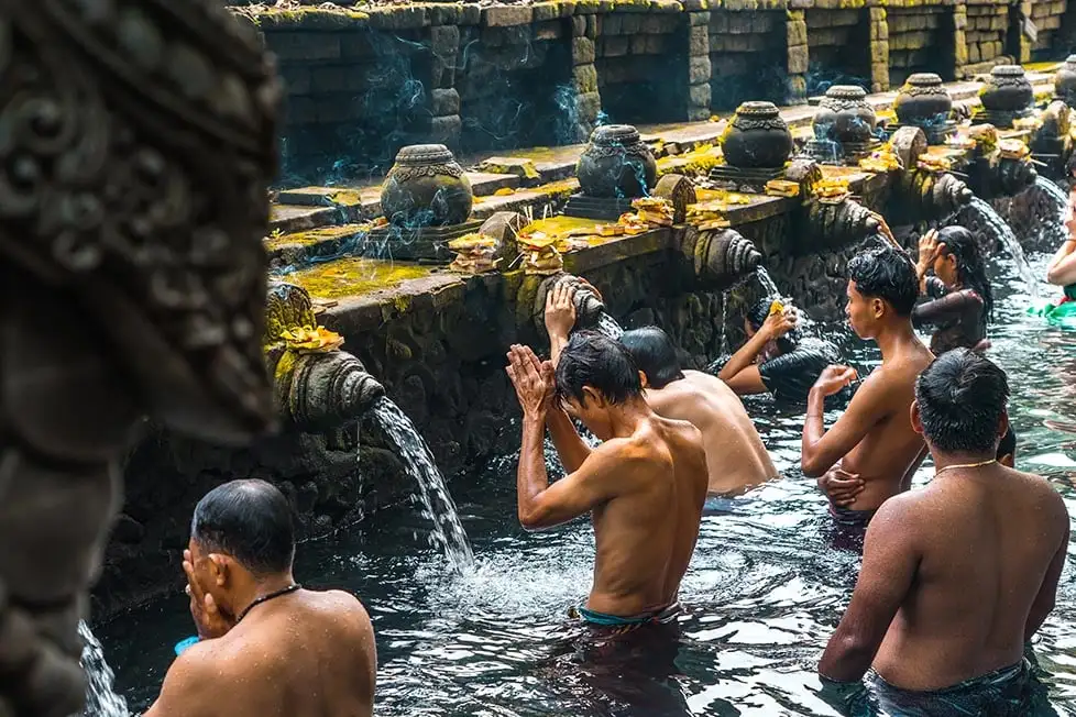Personnes priant au temple de l’eau à Bali, en Indonésie.