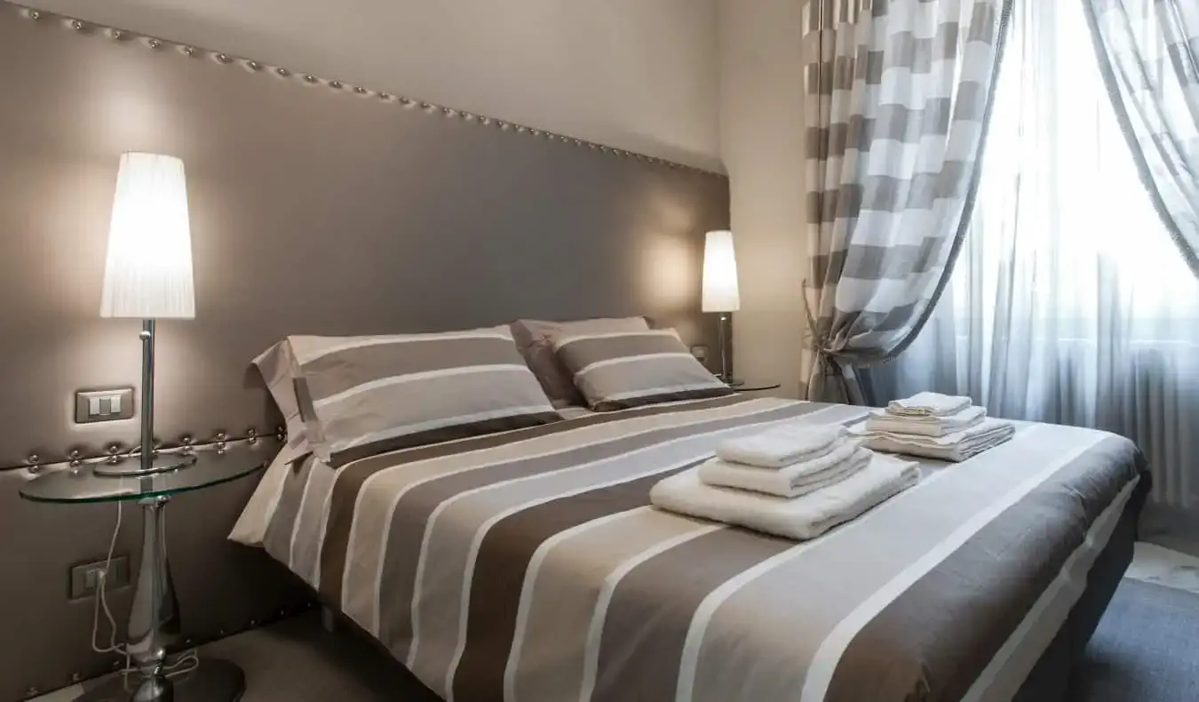 Una cama doble en una habitación de hotel decorada en estilo minimalista con distintos tonos de gris en Brera Prestige B&B, un hotel en Milán, Italia