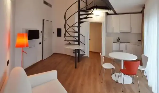 El área de la cocina y la sala de estar con una escalera de caracol que conduce a un loft en BB Hotels Aparthotel Isola en Milán, Italia