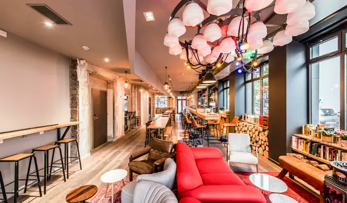 grand espace commun moderne avec canapés, chaises confortables et espace bureau et à l'auberge Les Piaules