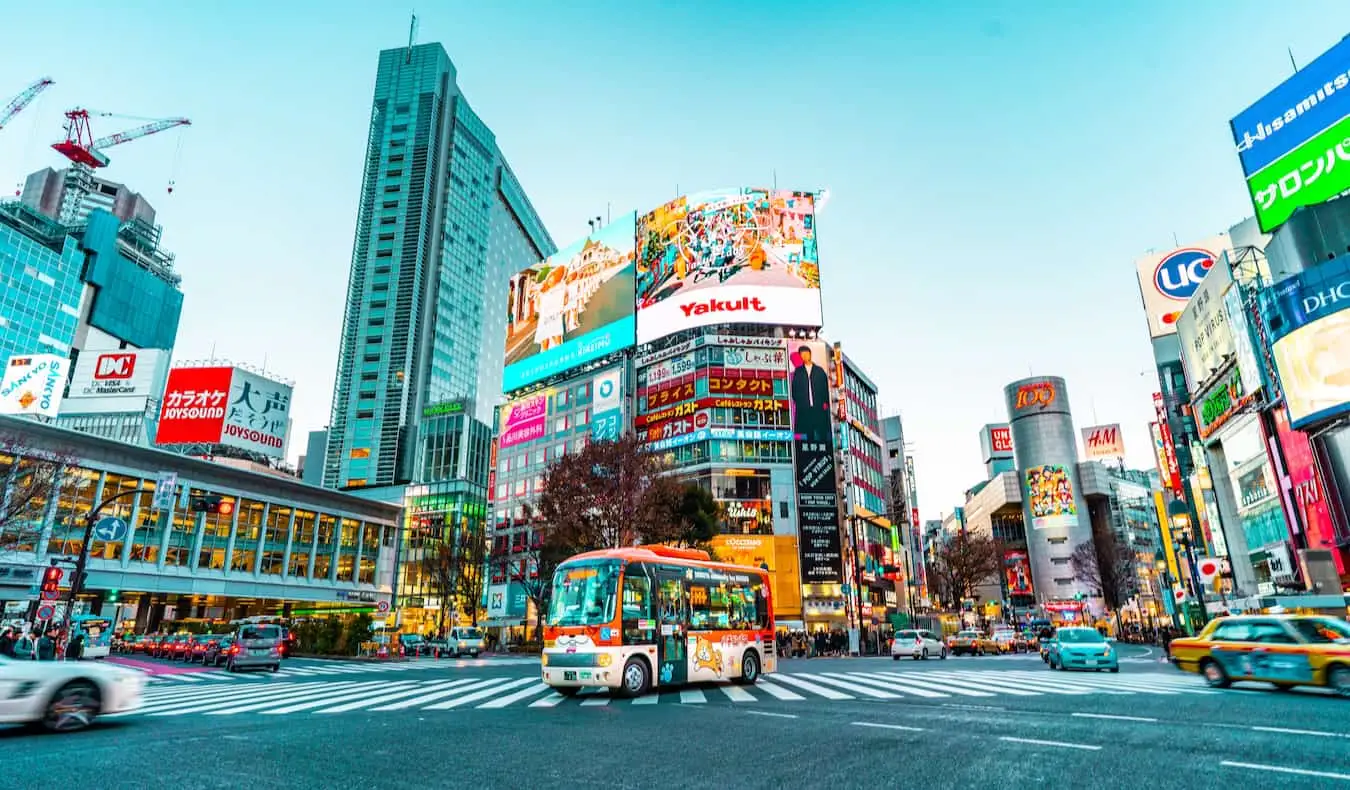 Pessoas atravessando a rua durante o trânsito intenso na área de Shibuya, em Tóquio, Japão