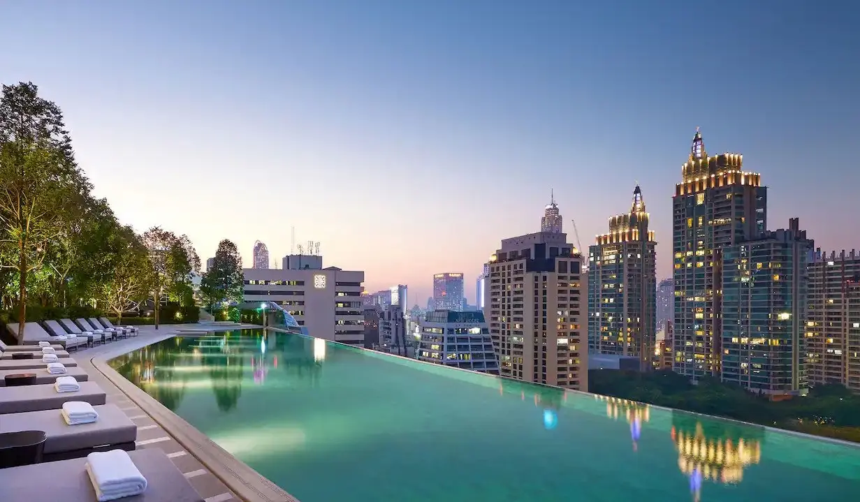 La piscine à débordement du Park Hyatt au crépuscule surplombant les toits de Bangkok, Thaïlande