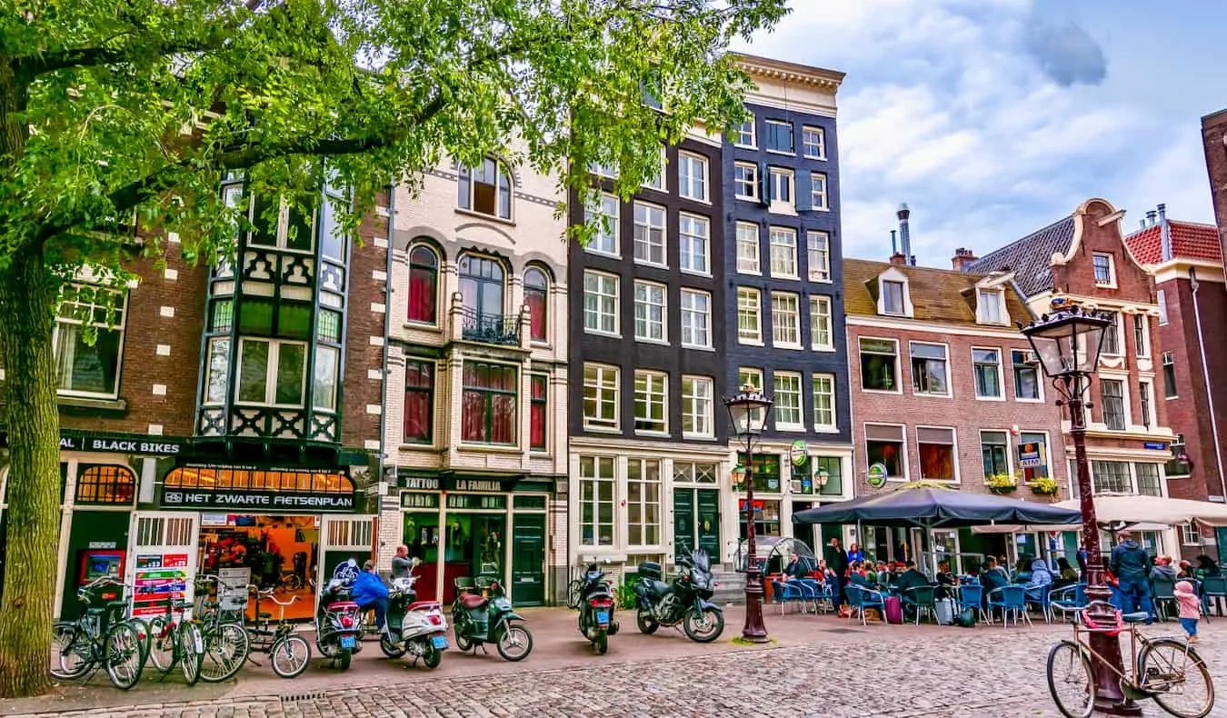 Pessoas relaxando ao longo dos canais de Amsterdã, Holanda