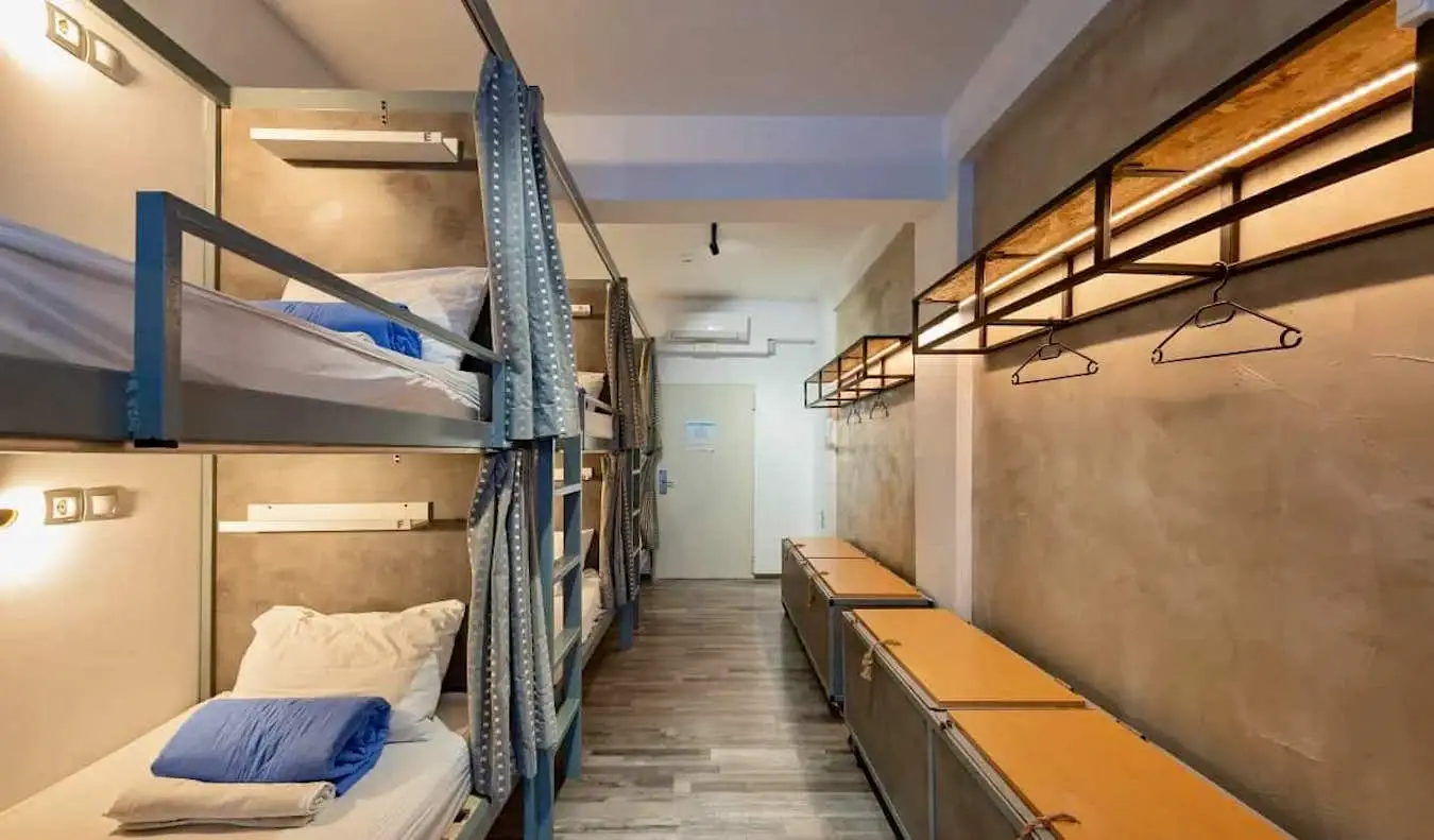 Camas aconchegantes com cortinas em um dormitório do albergue Bedbox em Atenas