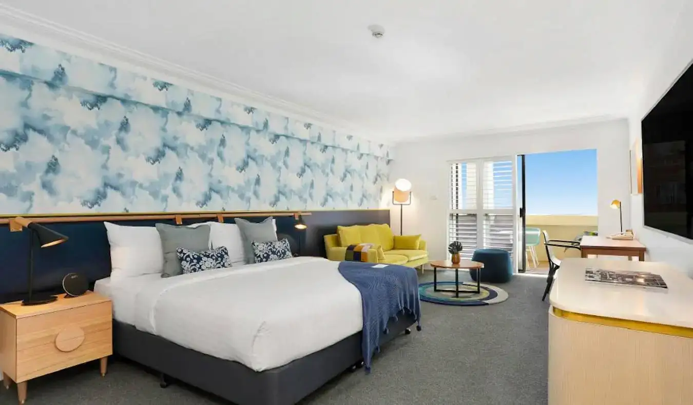 Um grande quarto de hotel com papel de parede com influência oceânica no Coogee Bay Hotel em Sydney, Austrália