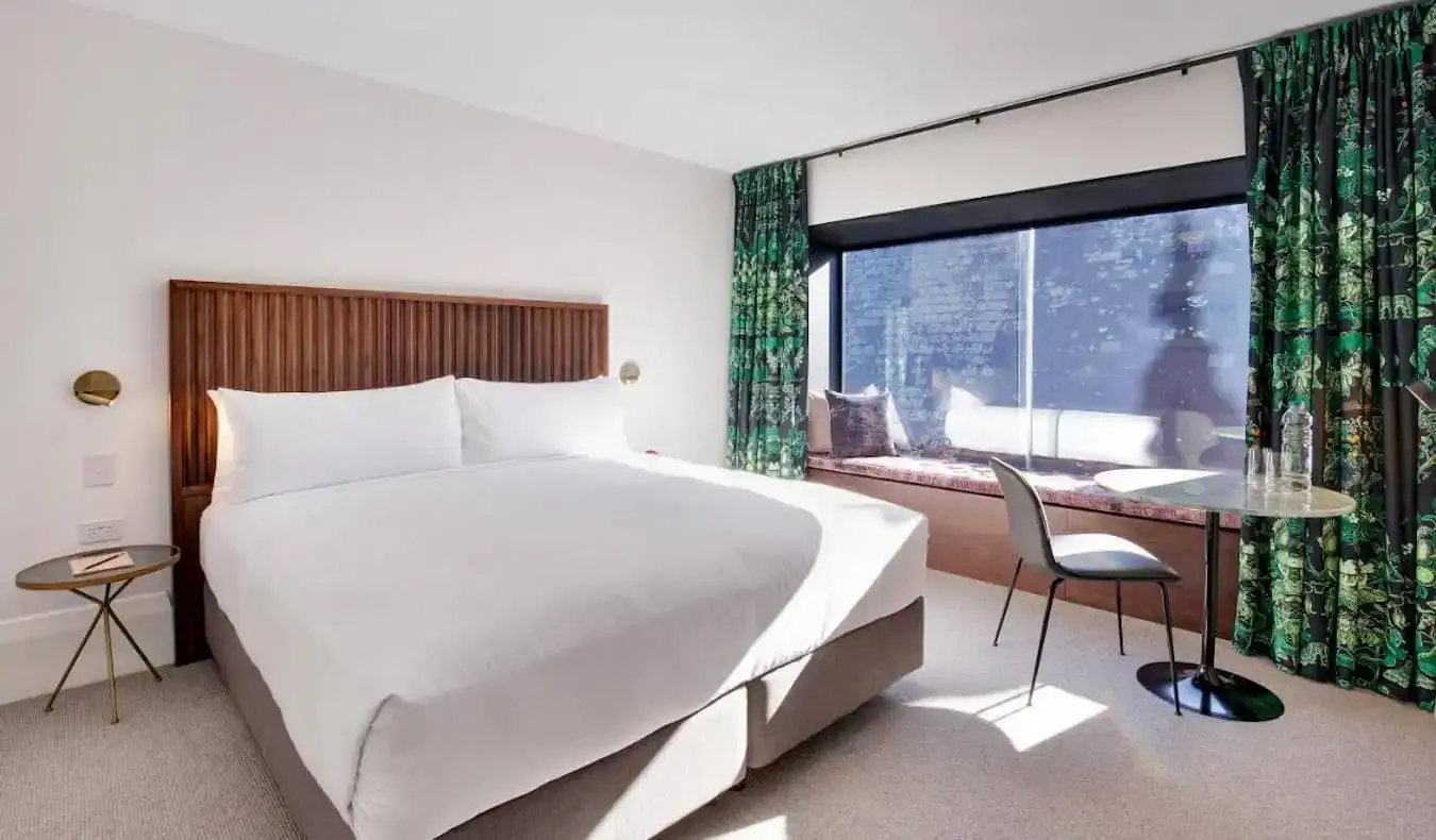 Um quarto de hotel grande e espaçoso com uma cama enorme no Crystalbrook Albion em Sydney, Austrália
