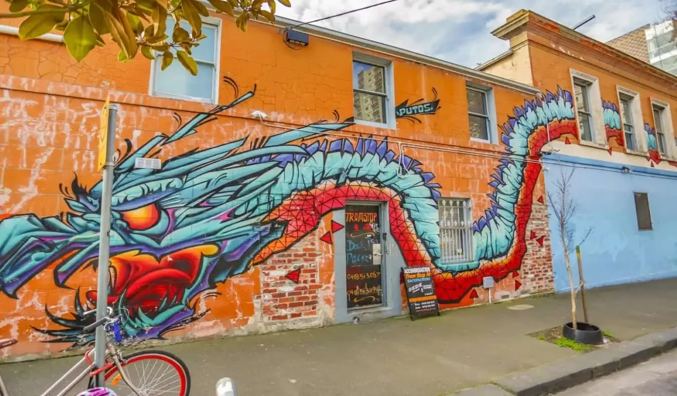 Extérieur de l'auberge Tramstop 14 Backpackers avec fresque murale en forme de dragon.