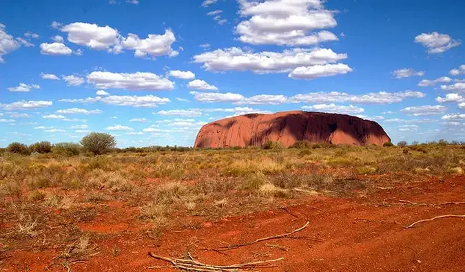 Uluru cercado pelo deserto na Austrália em um dia brilhante de verão