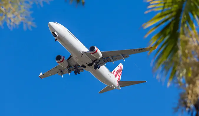 Um avião da Virgin Australia voando contra um céu azul brilhante