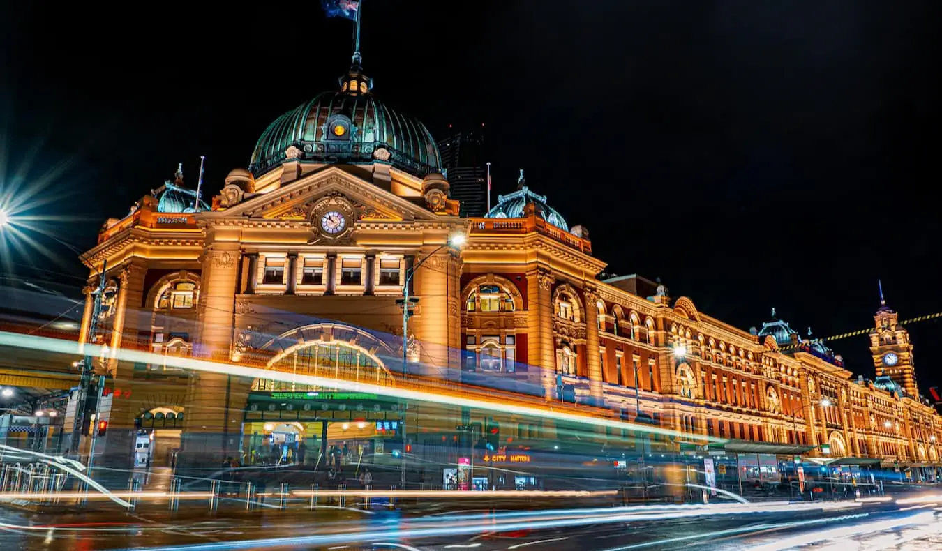 La gare historique de Flinders Street à Melbourne, en Australie, la nuit, avec la circulation qui passe