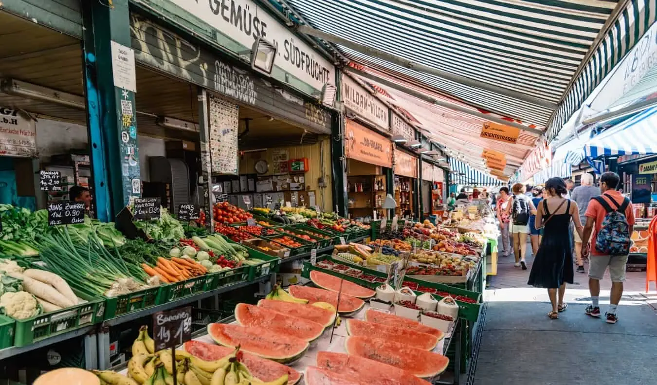 Les gens marchant dans les allées des produits du Naschmarkt et du marché extérieur de Vienne, en Autriche
