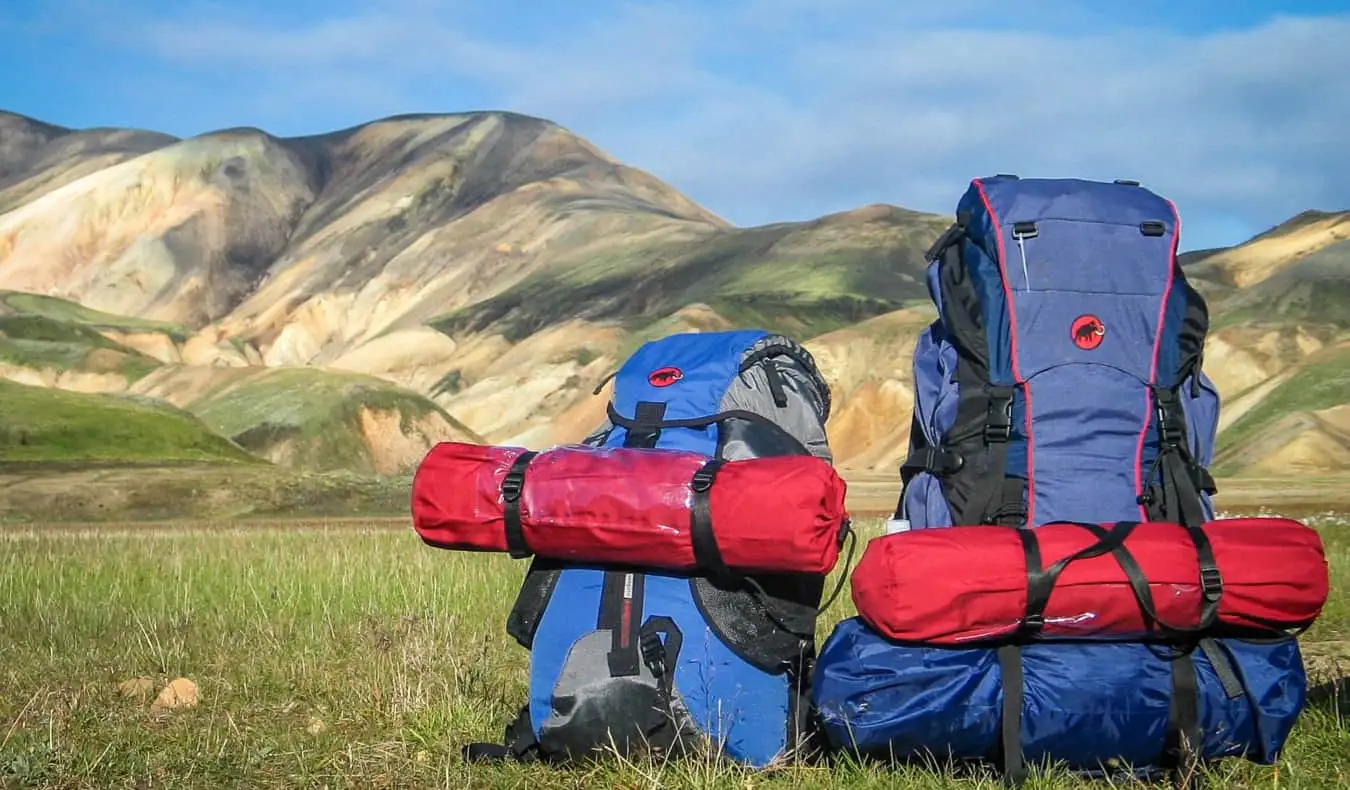 Um monte de equipamento de caminhada em um campo vazio