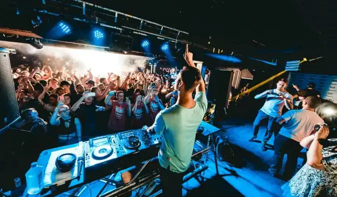 Un groupe de gens faisant la fête dans un club avec un DJ