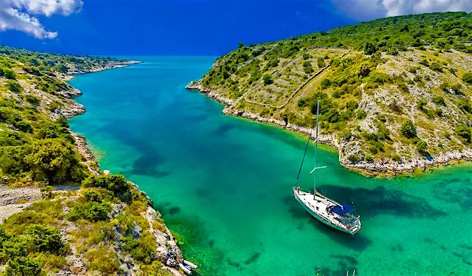 um veleiro flutuando em um rio estreito com lindas águas azul-turquesa