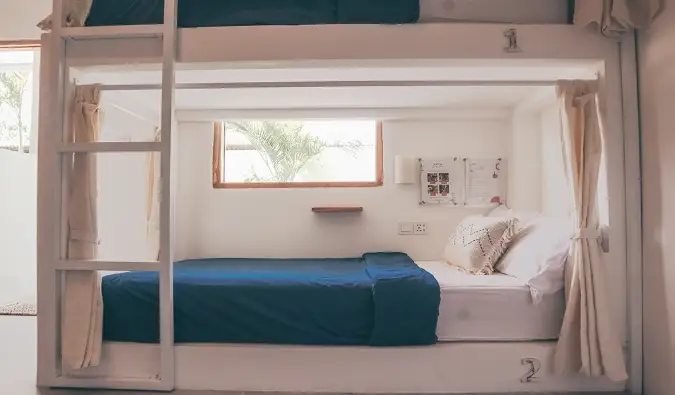 Lits superposés blancs de style capsule avec rideaux d'intimité à l'auberge Arya Wellness à Bali