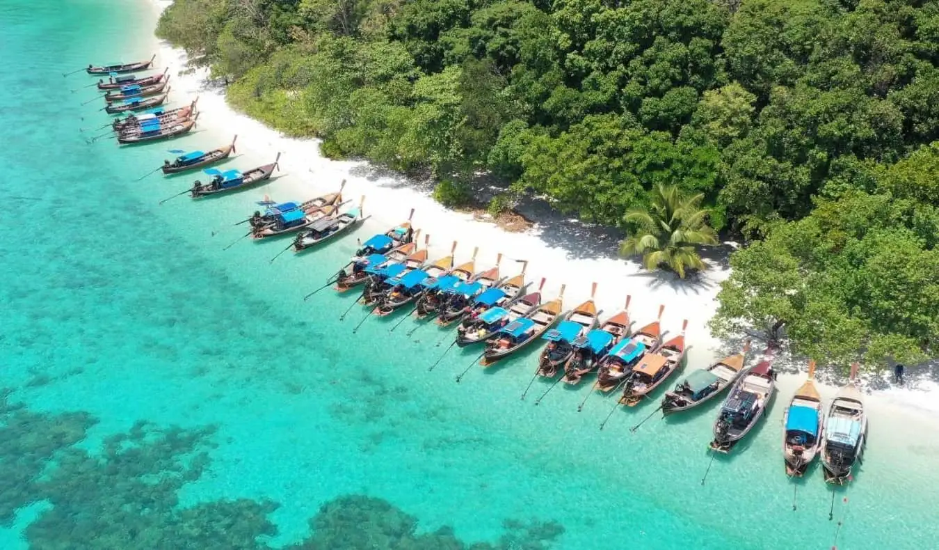 Vista aérea de uma linha de barcos longtail atracados em uma praia na ilha de Ko Lipe, Tailândia