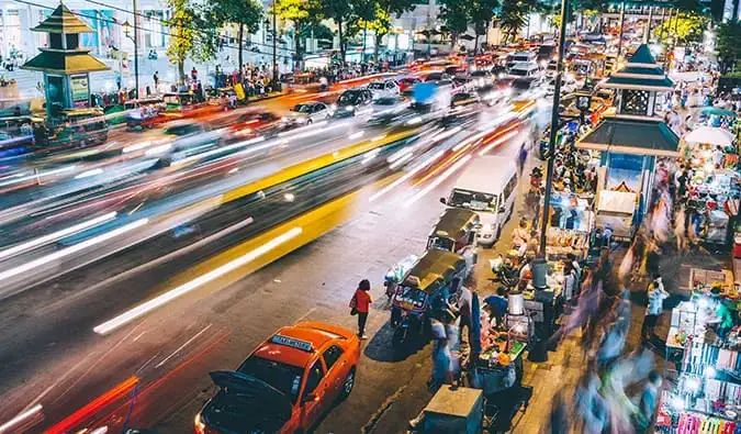 Photographie floue d'une rue animée la nuit à Bangkok